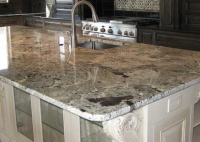 White And Black Marbled Granite Kitchen Counter For A Large Island With Center Bar Sink And Cream Cabinets